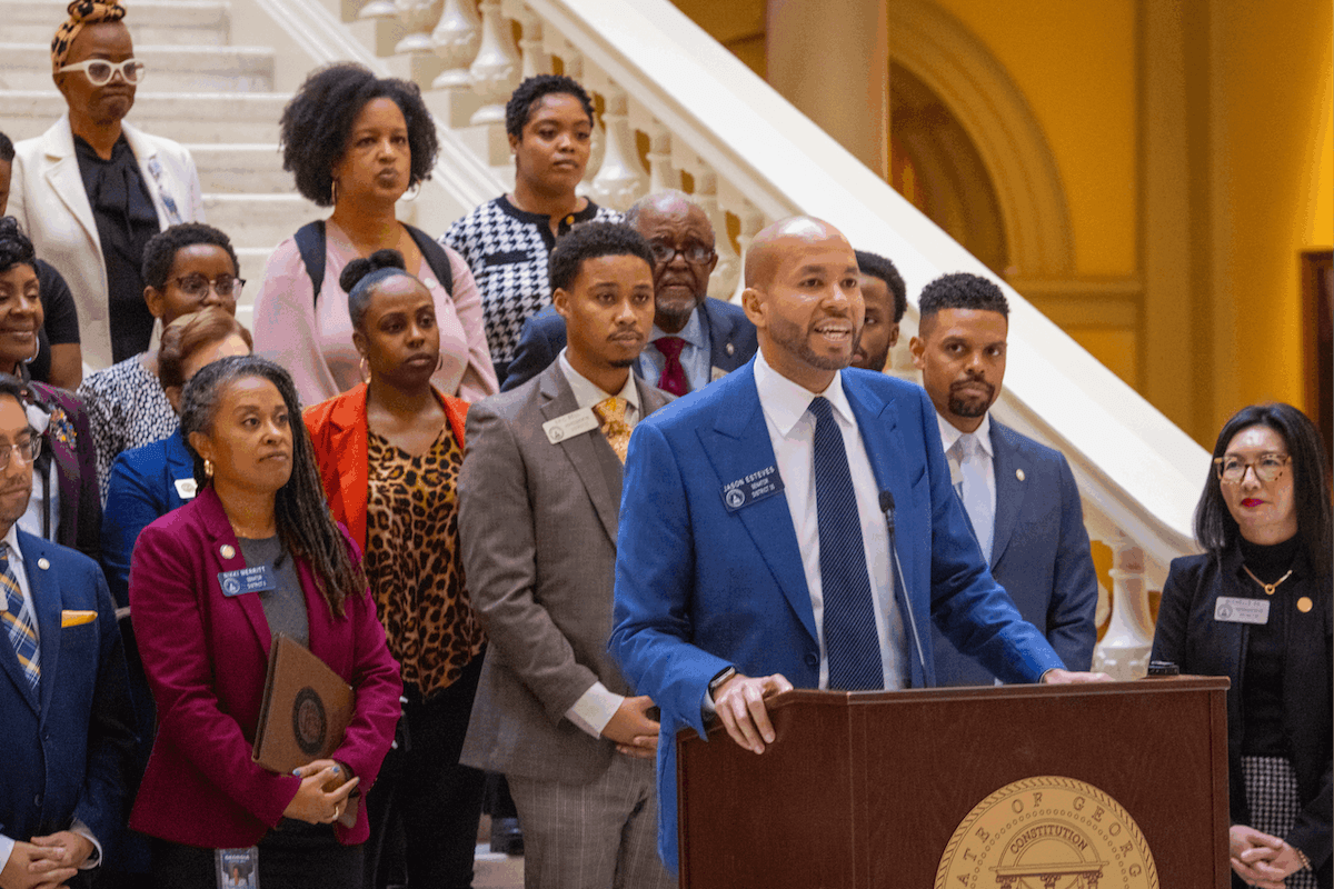 Jason Esteves standing at a podium giving a speech