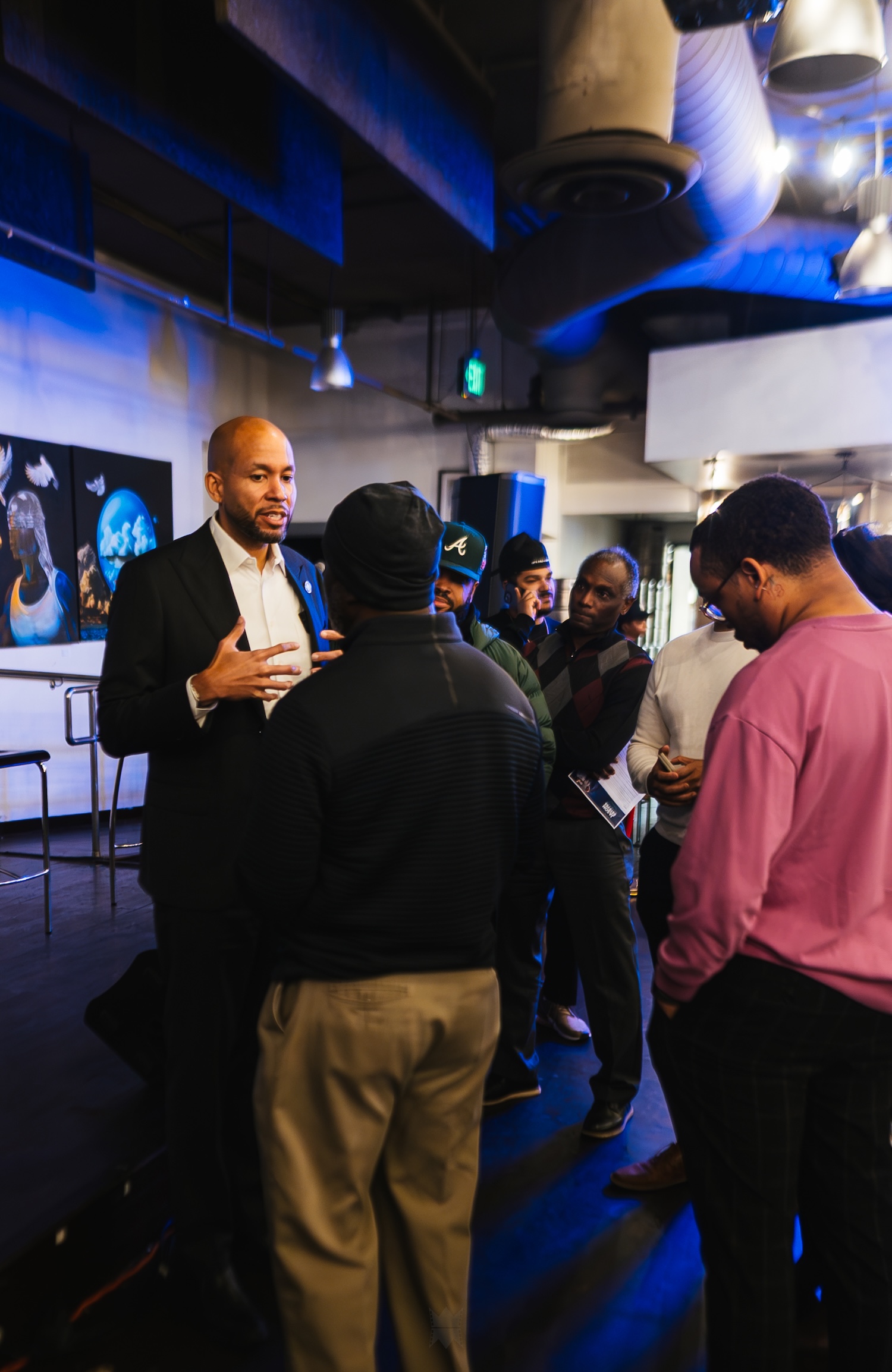 Jason Esteves talking to a group of Black men
